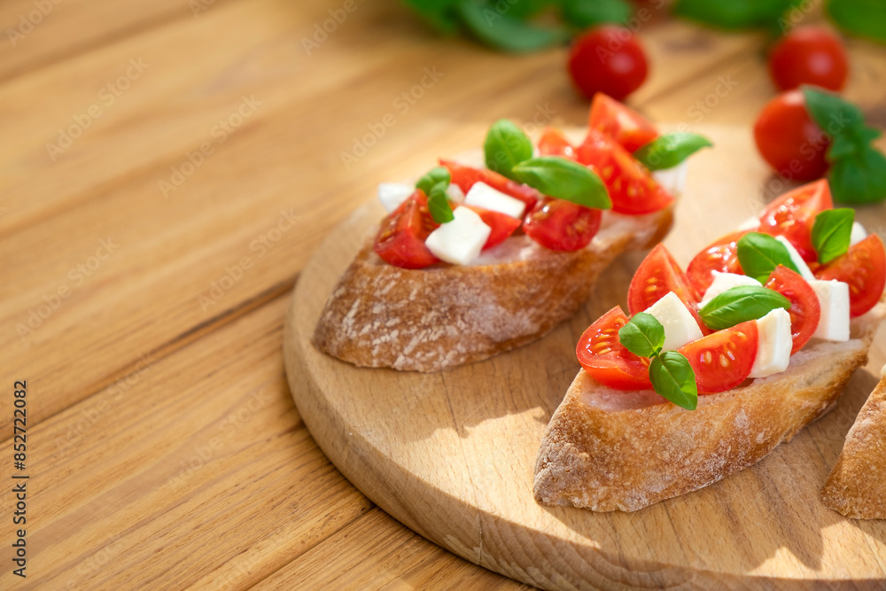 Sandwich with tomatoes, mozzarella cheese and basil on wooden board. Traditional Italian appetizer, toast, snack or antipasto. Vegetarian food. Healthy eating. Mediterranean food. Sandwich with tomatoes, mozzarella cheese and basil on wooden board. Traditional Italian appetizer, toast, snack or antipasto. Vegetarian food. Healthy eating. Mediterranean food.