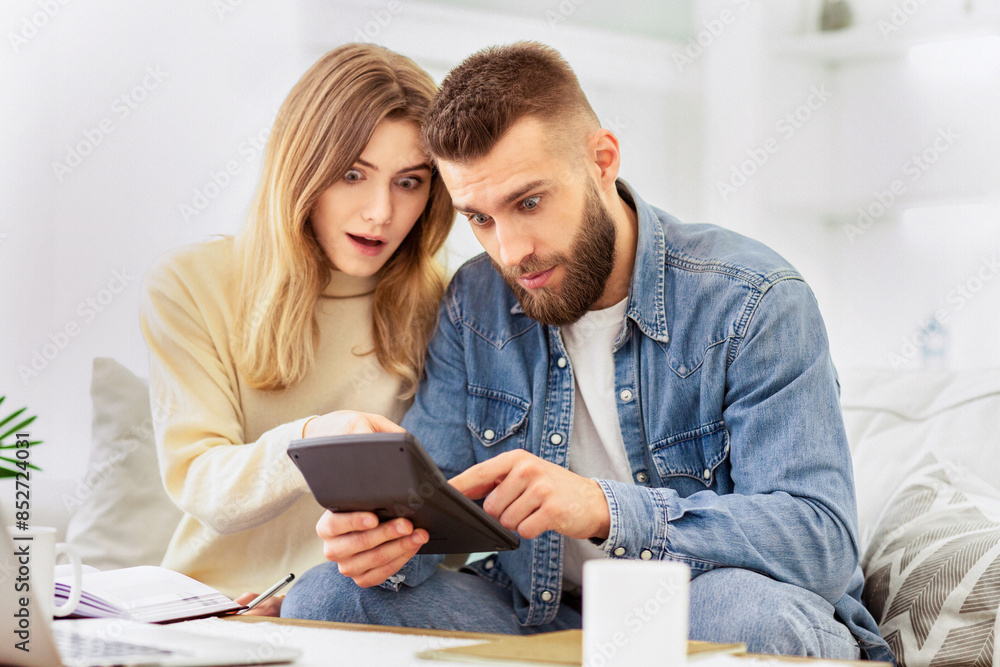 A man and woman are engaged, looking at something together on a tablet device. A man and woman are engaged, looking at something together on a tablet device.