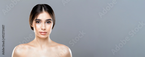 A woman without a shirt on is striking a pose while being photographed. She is confidently showcasing her figure in a bold manner, copy space, web-banner