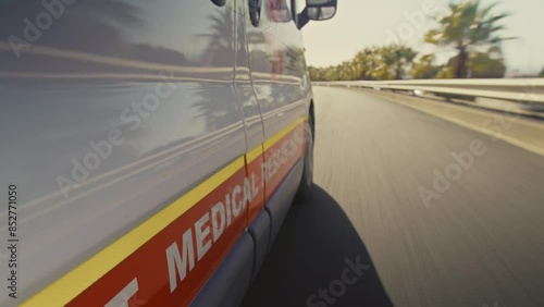 An ambulance driving fast on a highway photo