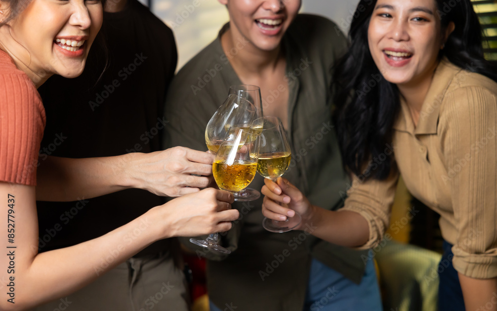 Close up hand holding glass. Group of young asian people smiling friends drinking at birthday party toast with beer. food and beverag Close up hand holding glass. Group of young asian people smiling friends drinking at birthday party toast with beer. food and beverag