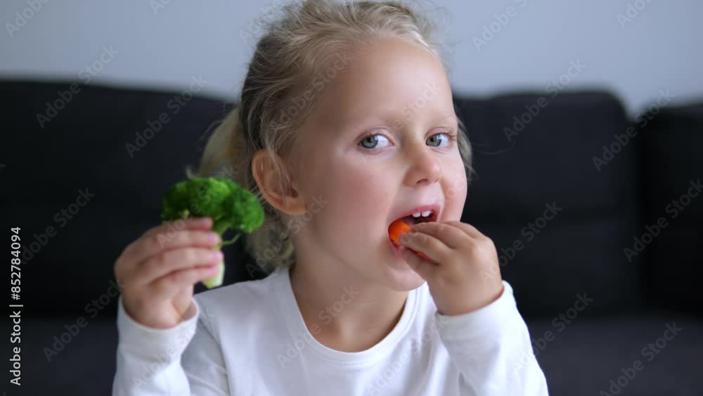 Young girl holds broccoli and carrots munching on them happily nutritious vegetables. Close-up shot to little girl holds broccoli and carrots eating them with curiosity vegetables healthy eating. Young girl holds broccoli and carrots munching on them happily nutritious vegetables. Close-up shot to little girl holds broccoli and carrots eating them with curiosity vegetables healthy eating.