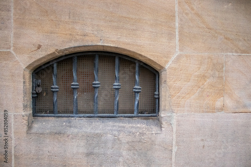 Historic stone wall with barred window. Copy space to advertise security grilles for windows photo