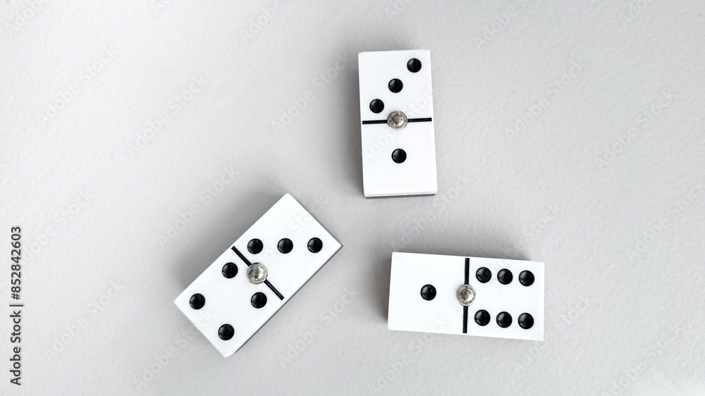 Three strategically placed white dominoes with black dots on a grey background symbolize strategy and decision-making, perfect for business or game-related concepts Three strategically placed white dominoes with black dots on a grey background symbolize strategy and decision-making, perfect for business or game-related concepts