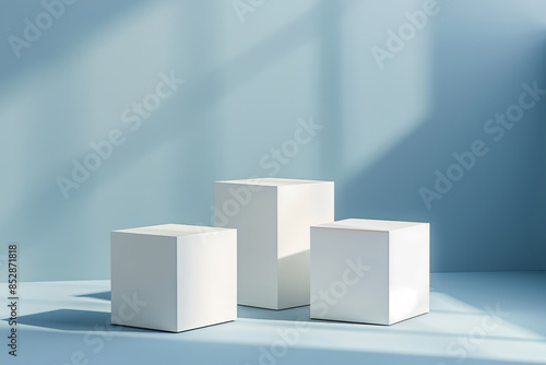 Three white cubes podiums on a pastel blue background, for product display mock up