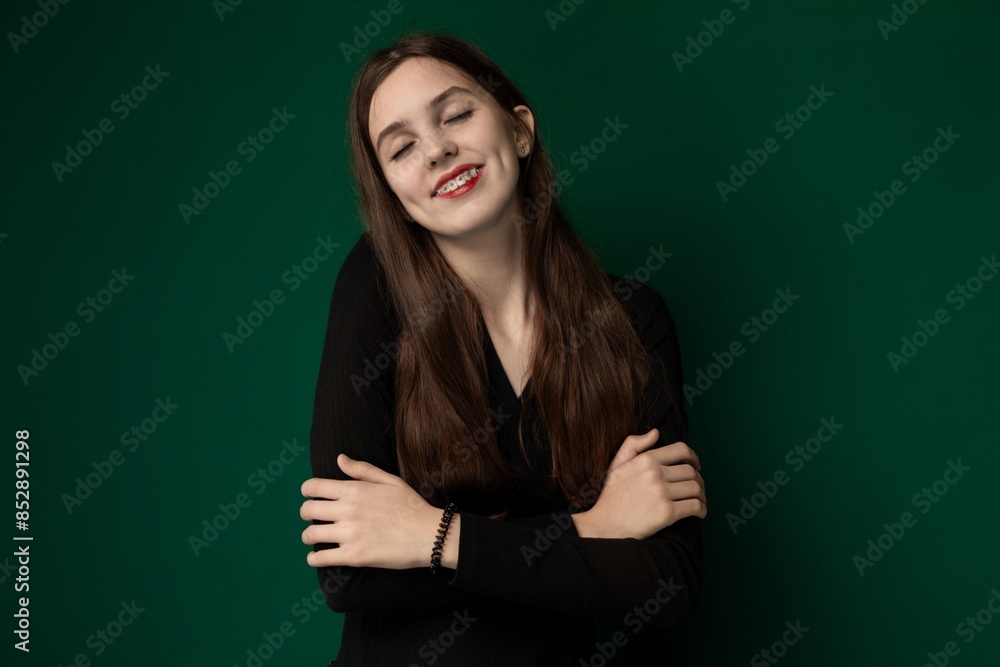 Woman With Arms Crossed in Front of Green Background Woman With Arms Crossed in Front of Green Background