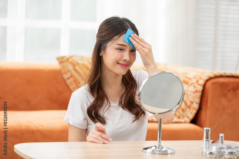 Woman Using Oil-Absorbing Film for Skincare in Bright Room Woman Using Oil-Absorbing Film for Skincare in Bright Room