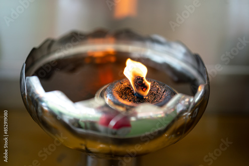 A candle lighting flame station at the temple or shrine, It provide for admirer people using to ignite incence or candle for preying the god. Close-up and selective focus. photo