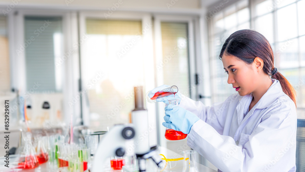Attractive young Asian scientist woman lab technician assistant analyzing sample in test tube at laboratory. Medical, pharmaceutical and scientific research and development concept Attractive young Asian scientist woman lab technician assistant analyzing sample in test tube at laboratory. Medical, pharmaceutical and scientific research and development concept