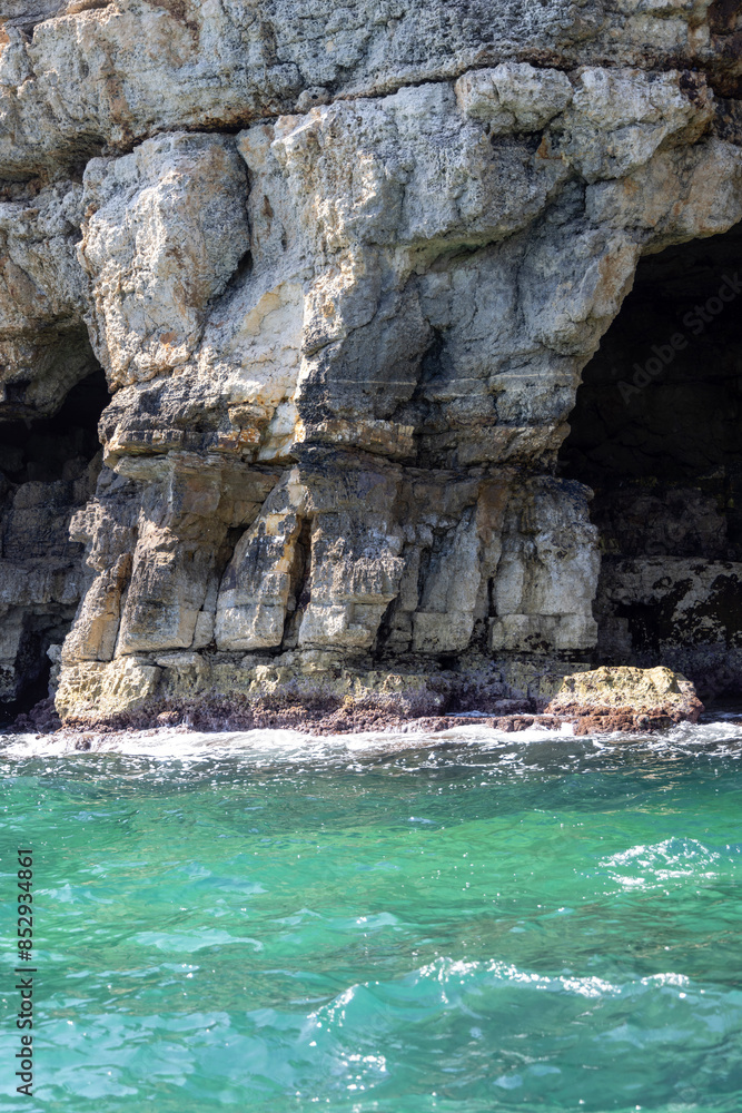 View from the water of picturesque coastline with cliffs and caves by Adriatic Sea, Polignano a Mare, Italy, Apulia