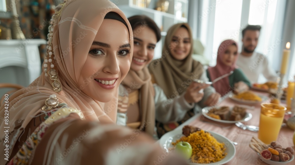 Muslim family at table for Eid Mubarak lunch and selfie. Ramadan celebration, culture, and iftar with home-cooked food, Islam, and religious holiday Muslim family at table for Eid Mubarak lunch and selfie. Ramadan celebration, culture, and iftar with home-cooked food, Islam, and religious holiday