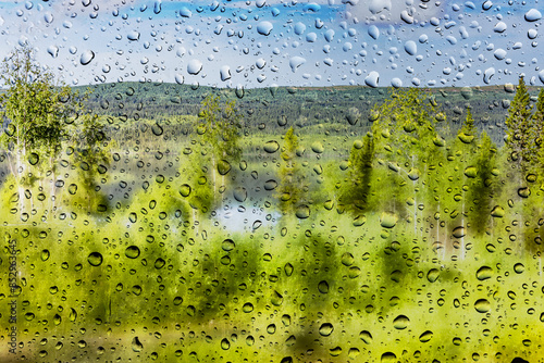 Regentropfen vor unscharfer Landschaft