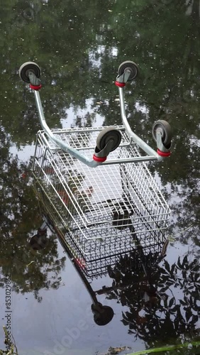 supermarket trolley drowned in water vertical video photo