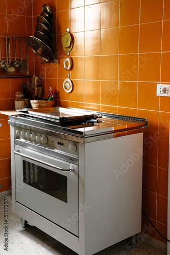 Old oven in an old kitchen with orange country-style tiles photo