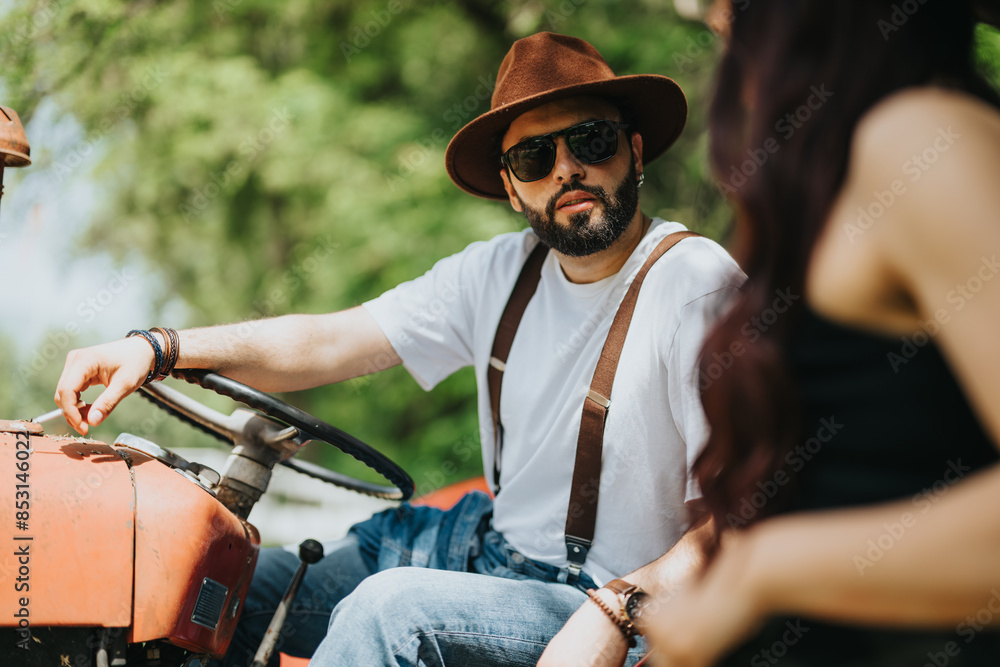 Man with beard, sunglasses, and hat steering a vintage tractor while talking to a person in a rural outdoor environment. Man with beard, sunglasses, and hat steering a vintage tractor while talking to a person in a rural outdoor environment.