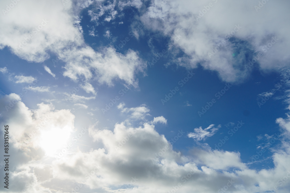 The sun shines through the clouds in a blue sky landscape The sun shines through the clouds in a blue sky landscape