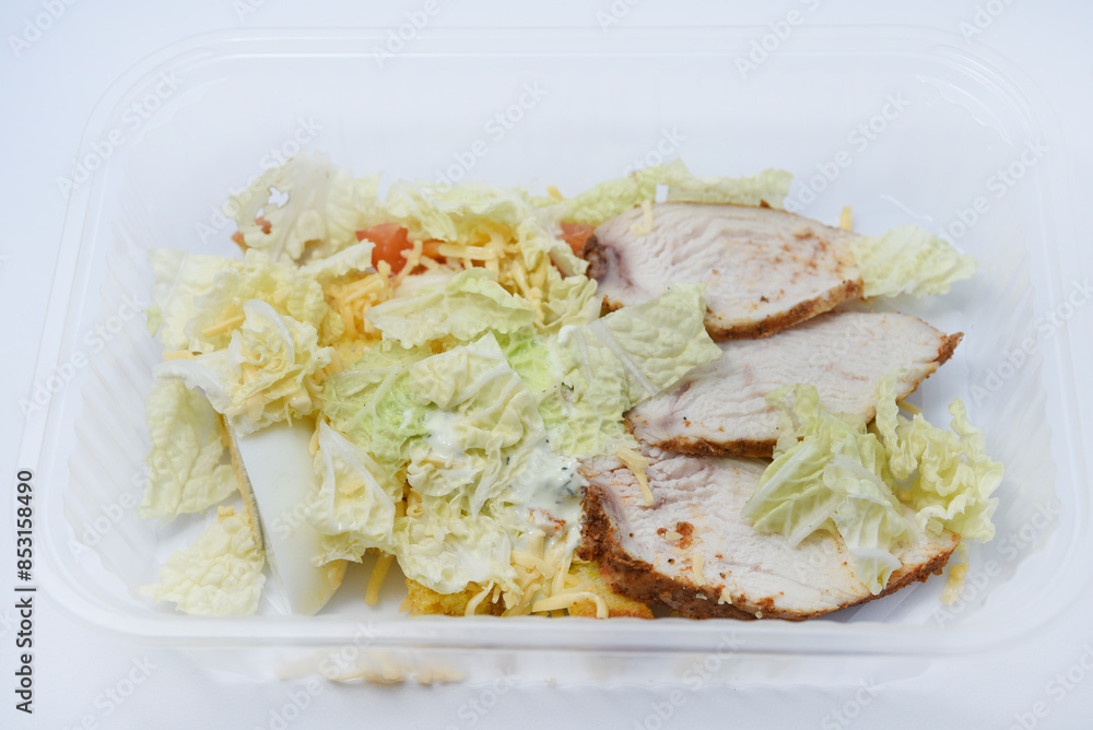 Caesar salad with meat and vegetables in a plastic container. A light breakfast. Caesar salad with meat and vegetables in a plastic container. A light breakfast.