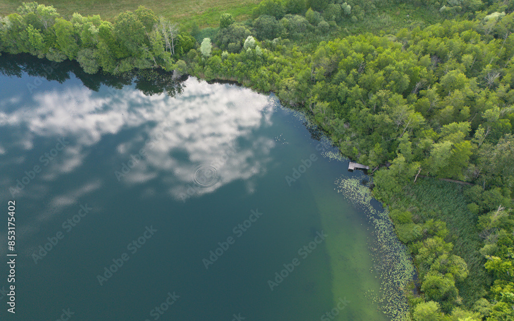 Reflets du ciel et des nuages sur le lac de Chavoley, sur la commune de Ceyzérieu, dans l'Ain en France à la fin du printemps Reflets du ciel et des nuages sur le lac de Chavoley, sur la commune de Ceyzérieu, dans l'Ain en France à la fin du printemps