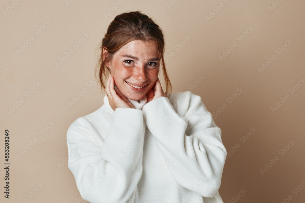 Smiling woman in white sweater portrait on beige background for fashion and beauty concept Smiling woman in white sweater portrait on beige background for fashion and beauty concept