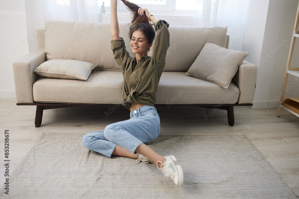 Obraz premium Happy Woman Relaxing on a Cosy Sofa in a Modern Apartment