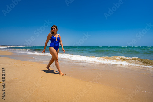 Beautiful woman walking on sunny beach Portugal, Algarve, praia Armona 