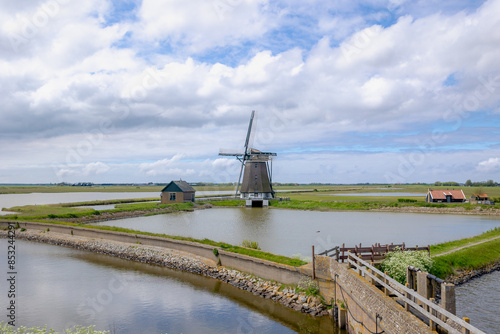 Traditional Molen Het Noorden (Windmills The North) A Dutch polder mill, Spring landscape with flat and low land with blue sky, Oosterend, Texel is the wadden islands in the Netherlands, North Holland