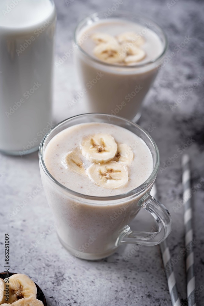 Banana milkshake with banana slices in a glass Banana milkshake with banana slices in a glass