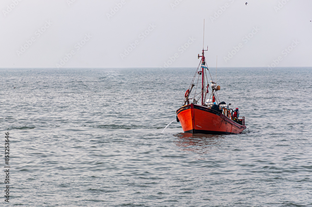 Fototapeta premium orange fishing boat sailing in the sea
