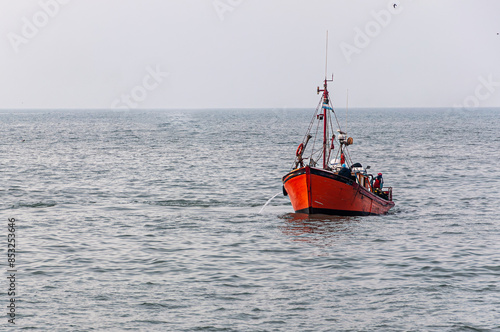 orange fishing boat sailing in the sea