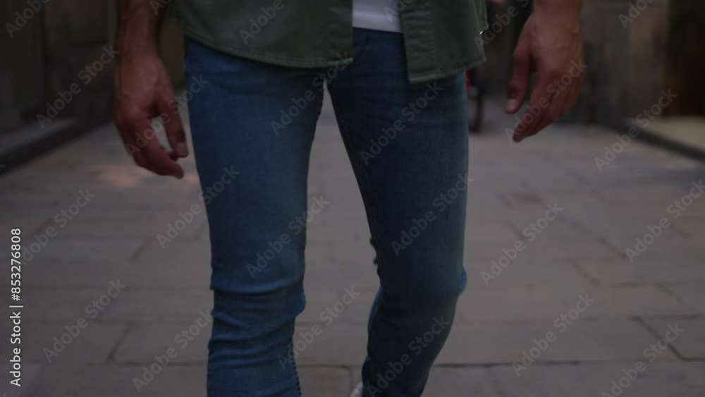 Young caucasian man walking cheerfully outdoors doing tourism. View from legs panning up to head. Slow motion footage. Young caucasian man walking cheerfully outdoors doing tourism. View from legs panning up to head. Slow motion footage.