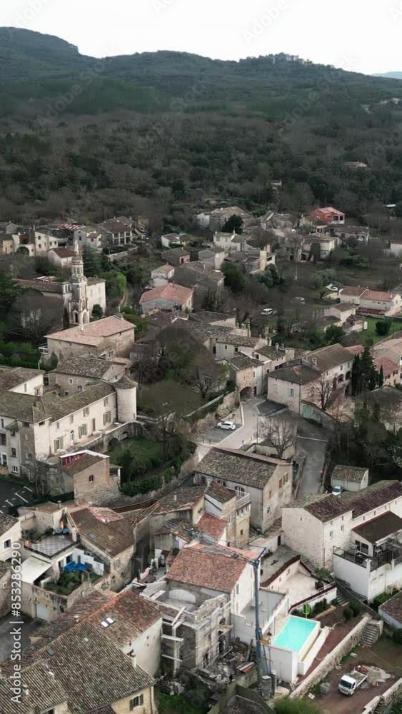 drone aerial shot of the town of Allegre les fumares in France among the mountains on a cloudy day where you can see all its architecture drone aerial shot of the town of Allegre les fumares in France among the mountains on a cloudy day where you can see all its architecture