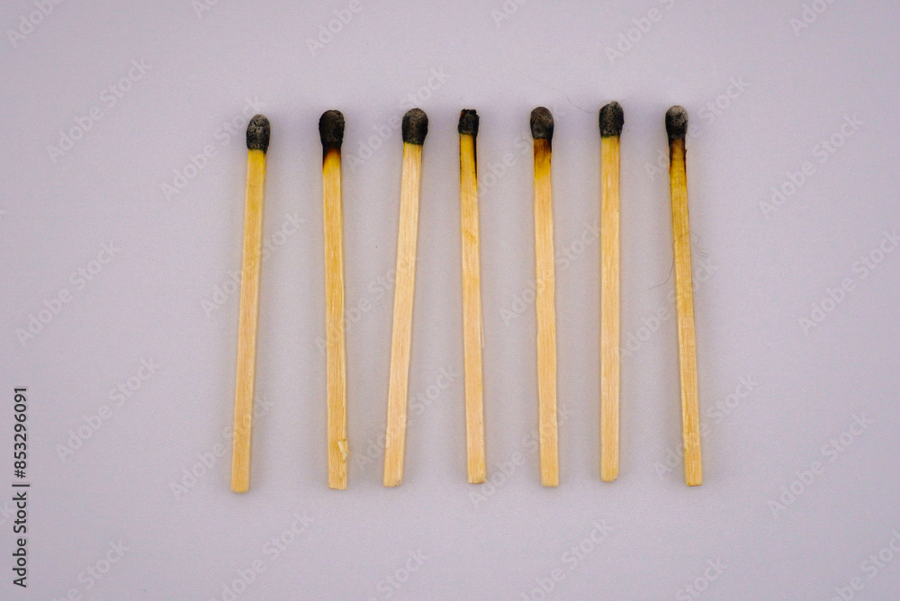 This is a close up picture of matches that have been burned, lined up in a row, to create and interesting pattern and background. This is a close up picture of matches that have been burned, lined up in a row, to create and interesting pattern and background.