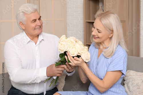 Mature man giving roses to ...