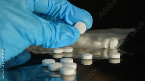Police investigator in blue gloves studying seized illegal drugs packed in vacuum bag. Forensic science criminalistics. Drugs in shape of pills seized by police. Crime scene and evidence.