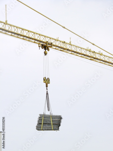 Dźwig budowlany przenoszący materiały budowlane na budowie photo