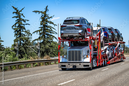 фотографія White pro industrial classic car hauler big rig semi truck transporting cars and