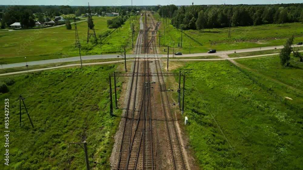 Aerial View of Railway Track through Green Landscape with Road Crossing, tranquil and scenic countryside environment Aerial View of Railway Track through Green Landscape with Road Crossing, tranquil and scenic countryside environment