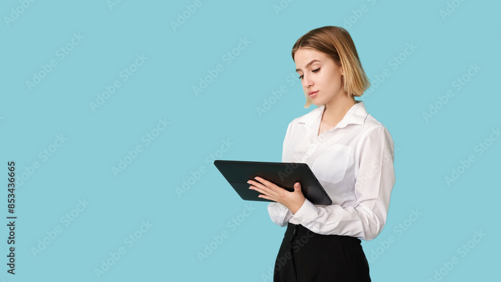 Corporate worker. Data analyzing. Online communication. Professional software. Busy elegant woman using tablet isolated on blue empty space. Corporate worker. Data analyzing. Online communication. Professional software. Busy elegant woman using tablet isolated on blue empty space.