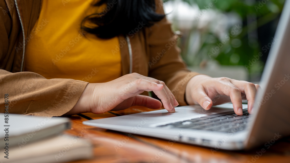 A close-up image of a woman working remotely, working on her laptop, typing on the keyboard. A close-up image of a woman working remotely, working on her laptop, typing on the keyboard.