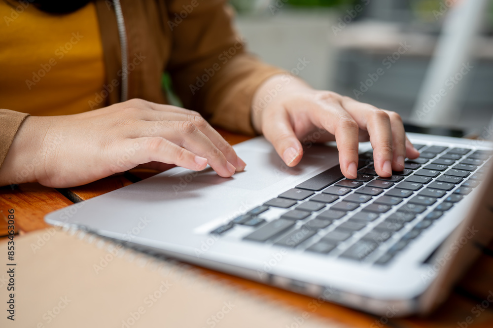 A close-up image of a woman working remotely, working on her laptop, typing on the keyboard. A close-up image of a woman working remotely, working on her laptop, typing on the keyboard.