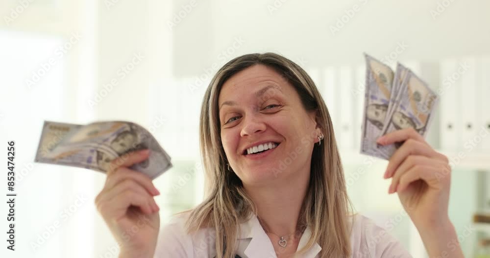 Happy doctor dances shaking dollar bills getting wage bonus Happy doctor dances shaking dollar bills getting wage bonus