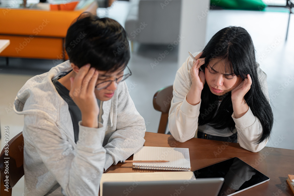 Two frustrated students are having a problem with their project and arguing while working together. Two frustrated students are having a problem with their project and arguing while working together.