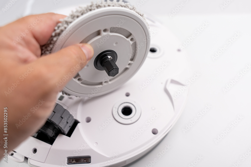 A person is holding a white object with a black part. The object is a vacuum cleaner A person is holding a white object with a black part. The object is a vacuum cleaner