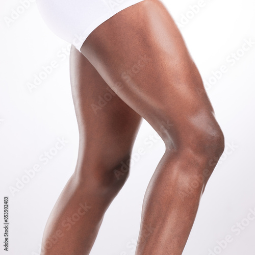Person, legs and muscles in studio with fitness for workout progress, exercise goals and wellness. Bodybuilder, muscular athlete and flexing thighs for healthy body and gym target on white background
