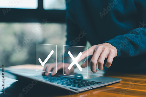 Fotografie decide to choose to vote check right and wrong marks on a laptop, yes or no decisions