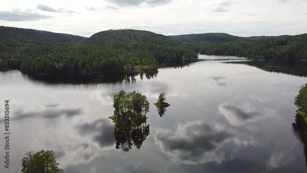 A peaceful lake in Norway surrounded by lush green forests, with small tree-covered islands reflecting on the calm water A peaceful lake in Norway surrounded by lush green forests, with small tree-covered islands reflecting on the calm water