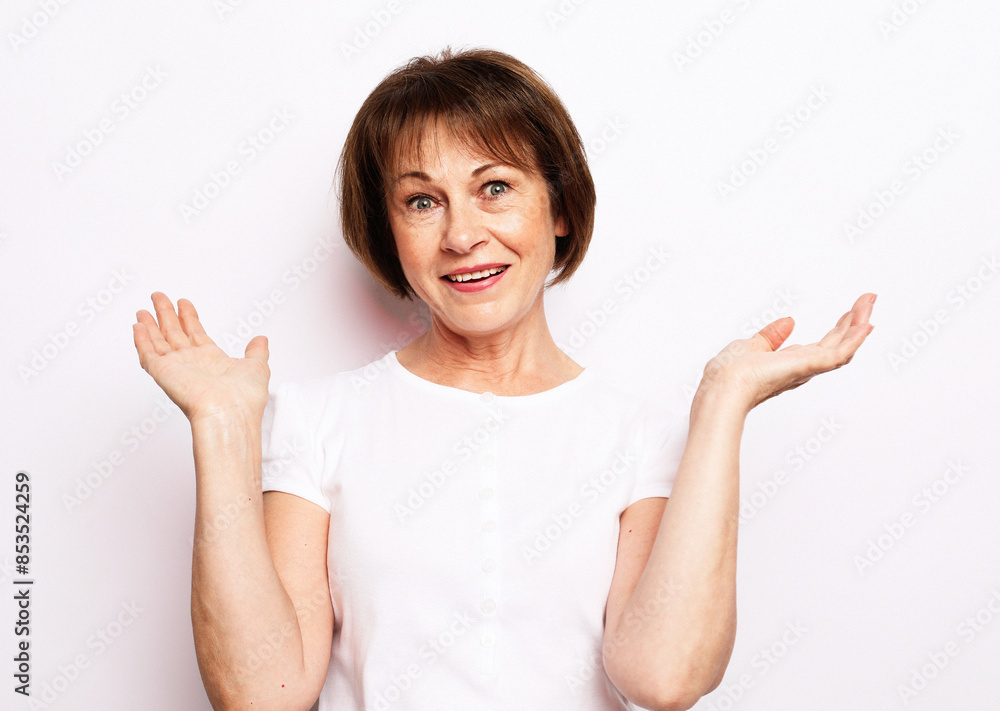 Close-up portrait of shocked mature woman in white t-shirt, looking at camera Close-up portrait of shocked mature woman in white t-shirt, looking at camera