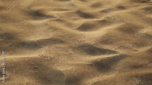 Close up shot of sand being blown into dune shapes photo