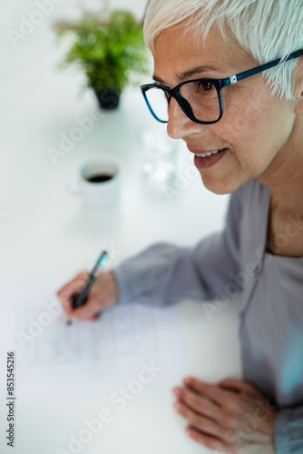 A senior woman enjoys solving Sudoku puzzles, part of cognitive therapy to enhance mental acuity and cognitive skills