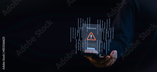 Obraz na płótnie a hand holding a smartphone warning sign indicating a payment system warning. the alert, symbolizing online security threats, scam alerts, and the importance of secure digital transactions w salonie